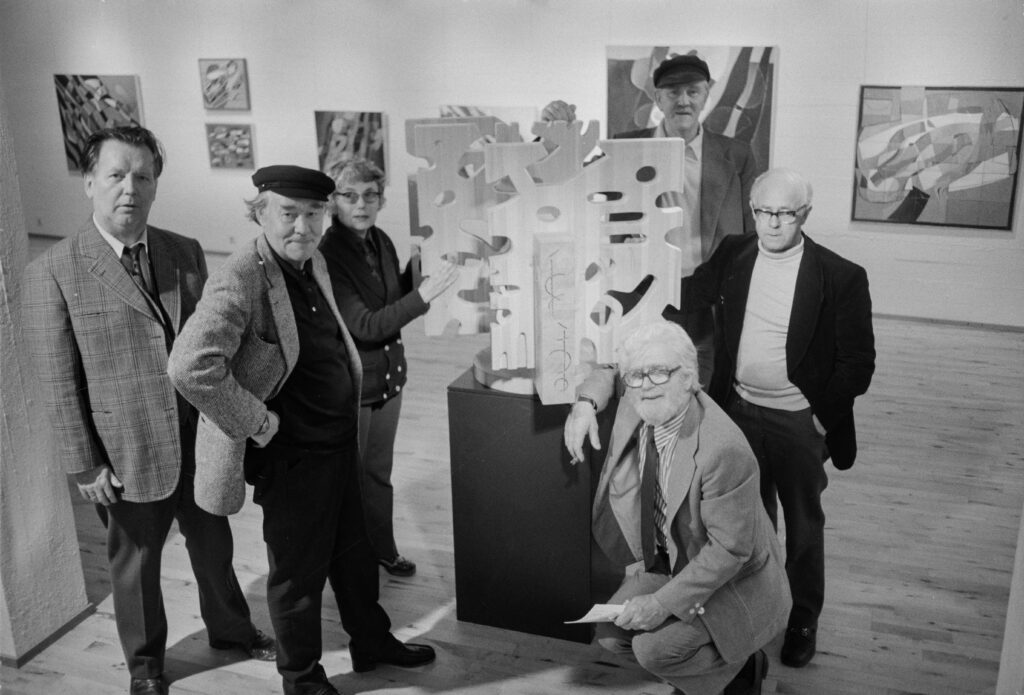 Gagnrýnendur og sýnendur. F.v. Karl Kvaran, Valtýr Pétursson, Ragnheiður Jónsdóttir Ream, Kristján Davíðsson, Magnús Pálsson og Sigurjón Ólafsson, uppstillt kringum tréskúlptúr hans. Ljósmyndari: NN, Tíminn. © Ljósmyndasafn Íslands.